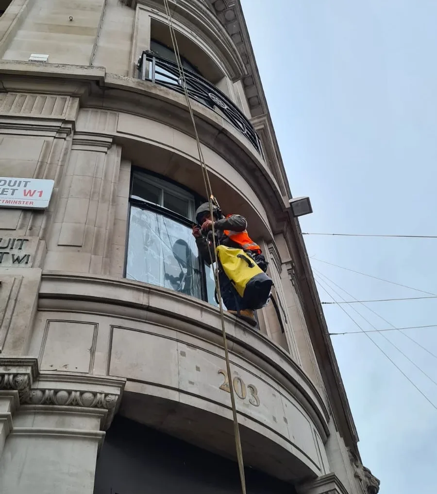 Rope access technicians carrying out balustrade repair on a high rise building in London to restore safety and structural integrity