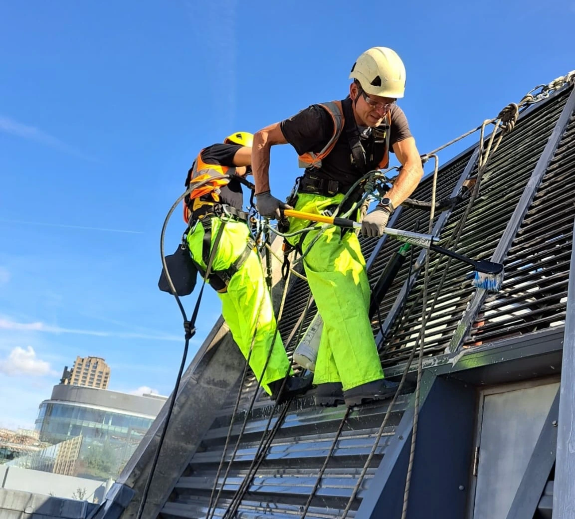 Rope Access Cleaning London Rope access technicians carrying out cleaning on a high rise building in London to remove dirt and debris from the facade