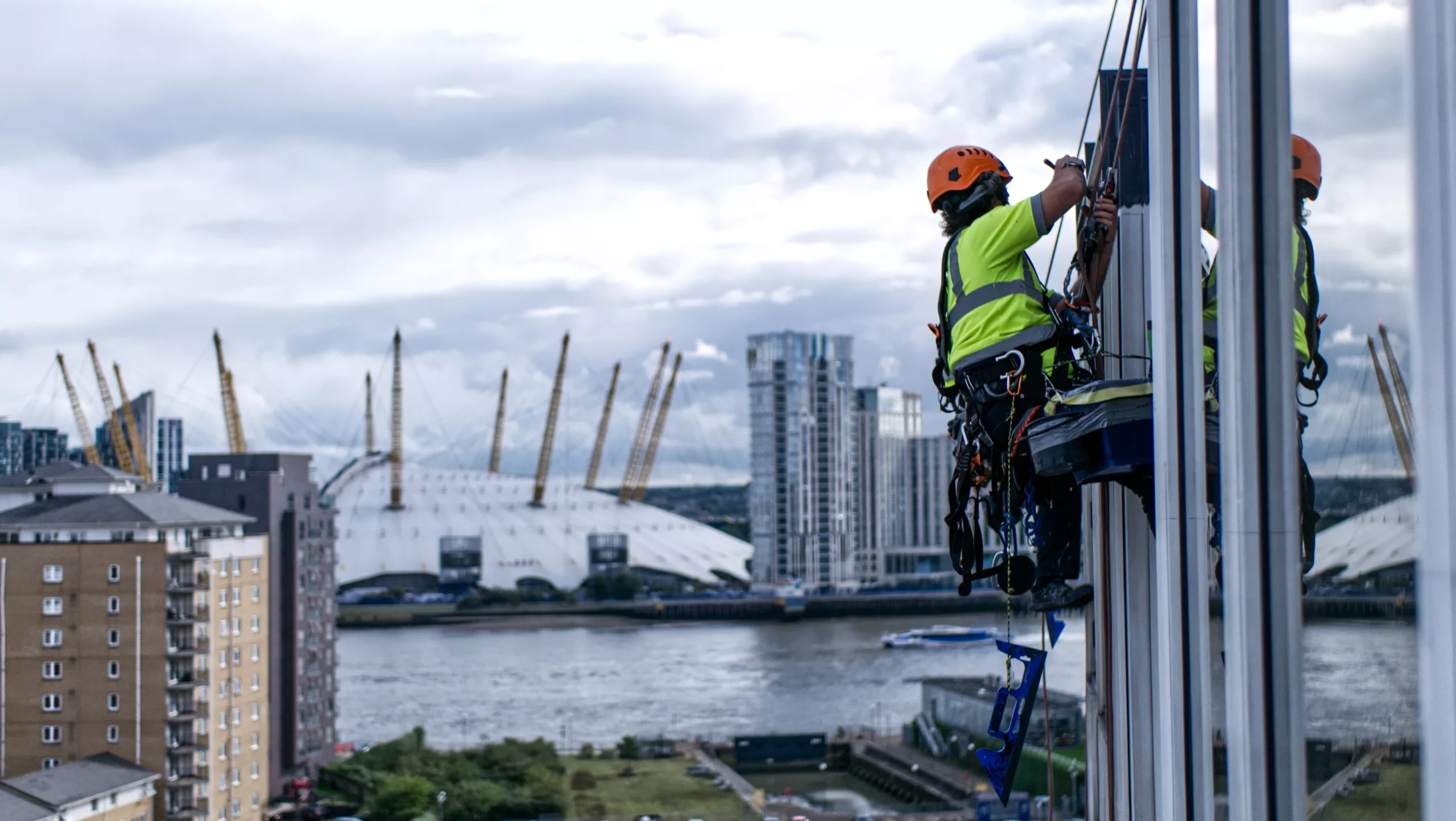 Rope access technicians performing commercial painting on a high rise building in London to protect and enhance exterior surfaces