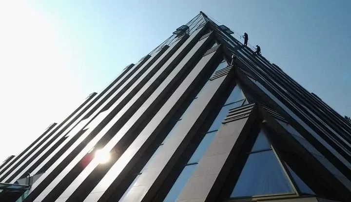 Rope access technicians carrying out high level roofing work on a building in London to inspect repair and maintain the roof structure
