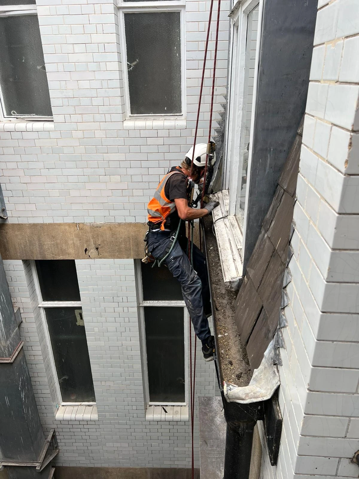 Rope access technicians performing waterproofing on a lightwell in London to prevent water ingress and protect structural integrity