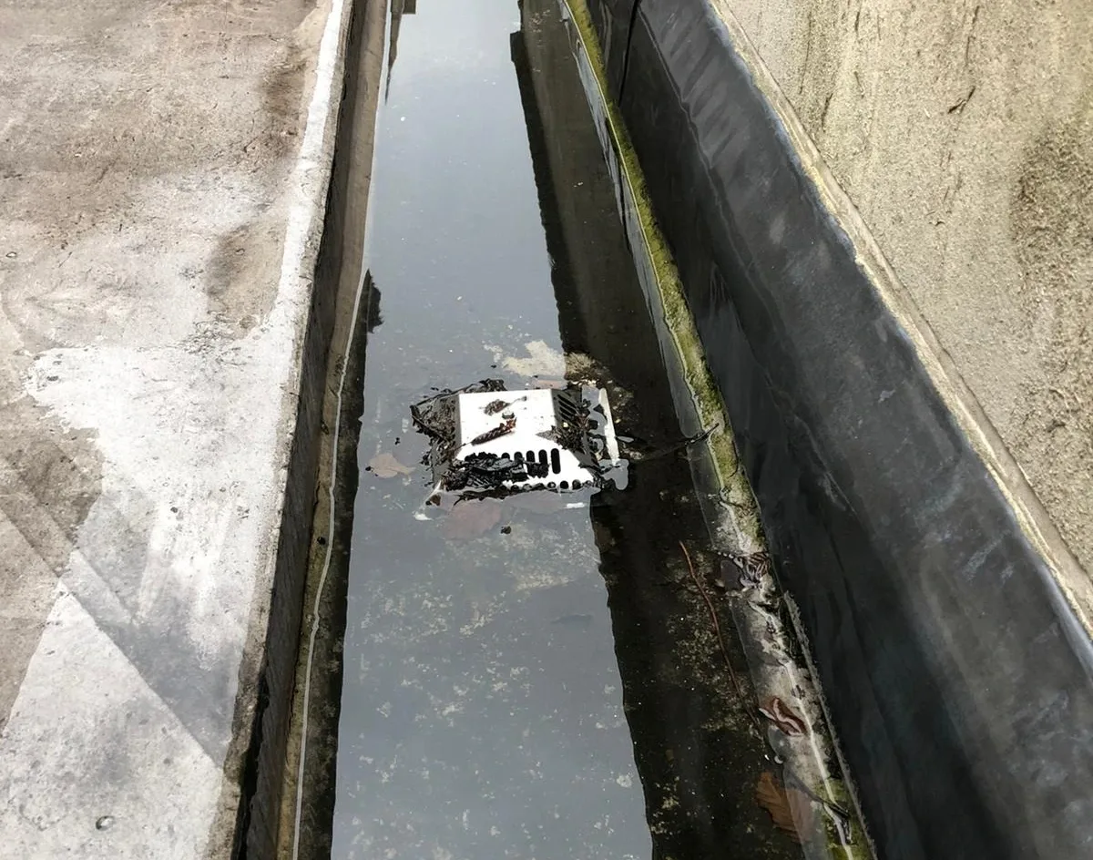 Rope access technicians clearing and maintaining outlet gutter downpipes on a high rise building in London to ensure efficient drainage and prevent water buildup