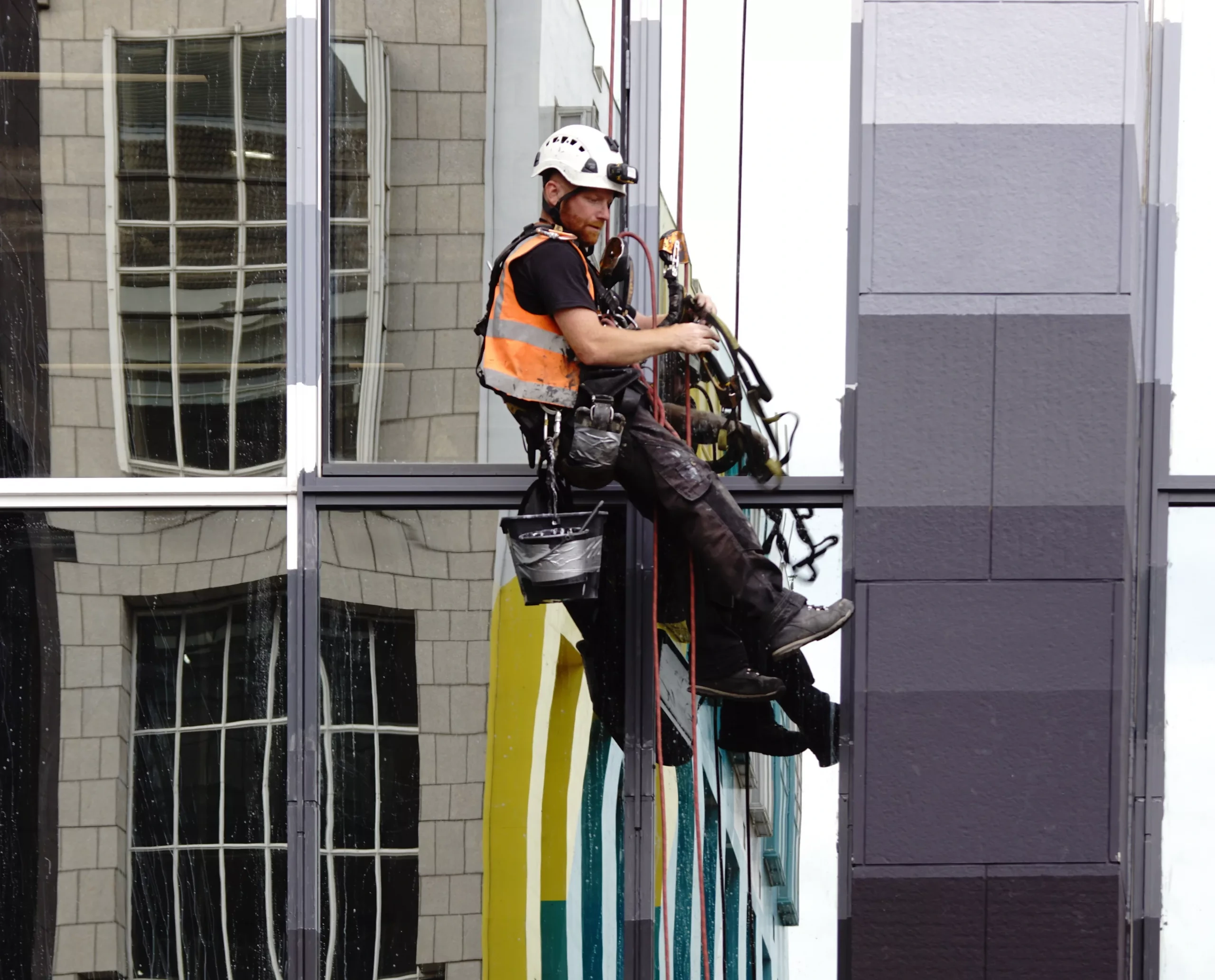 Rope access technicians carrying out painting on a high rise building in London to protect and enhance the exterior surfaces