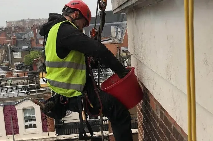 Rope access technicians delivering services on a high rise building in London for maintenance inspection and repairs