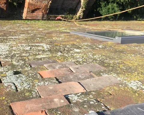 Rope access technicians installing and repairing slate roofing on a high rise building in London to ensure durability and weather protection