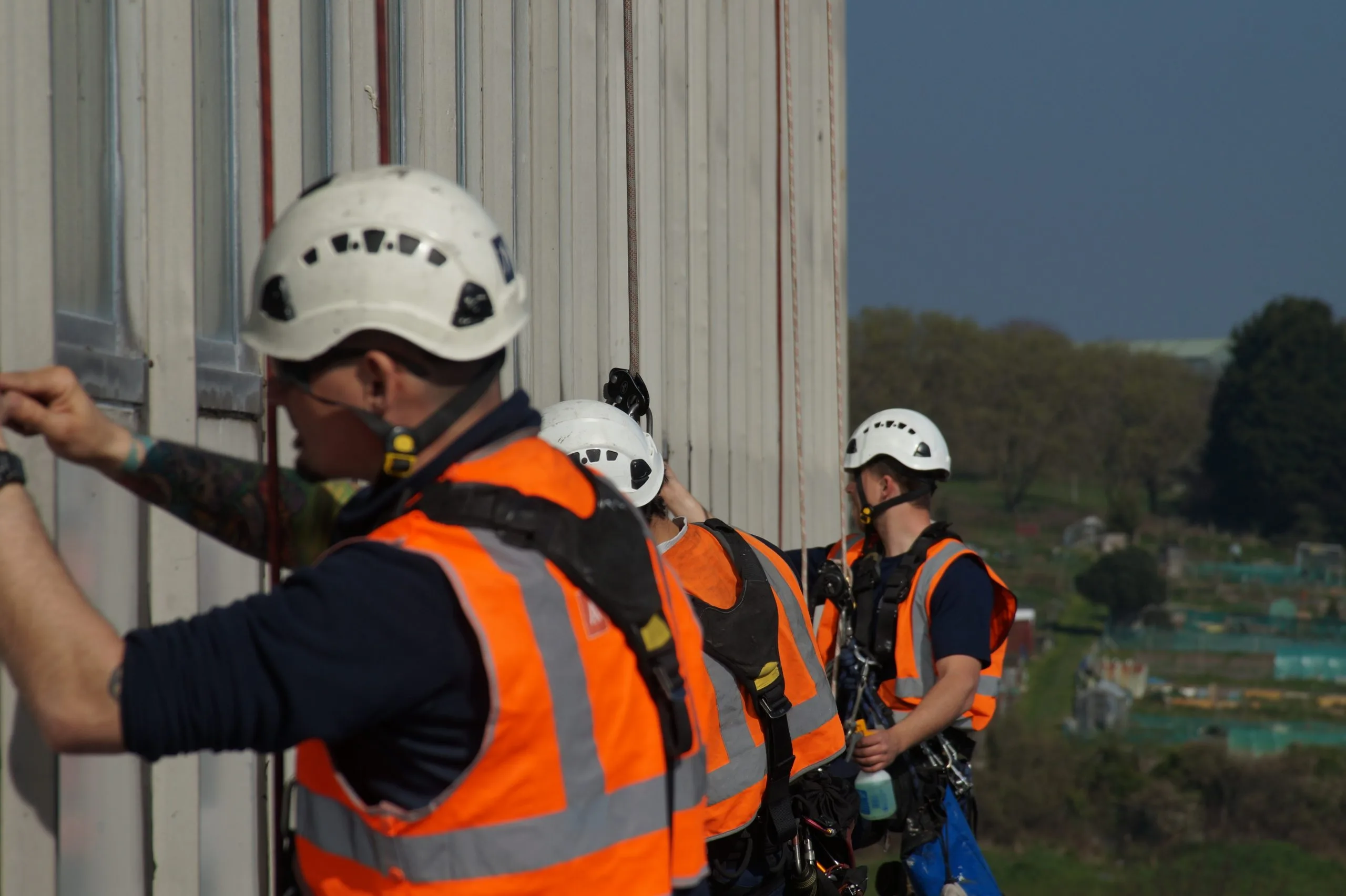 Rope Access Window & Curtain Wall Sealing – Leak Prevention & Insulation Rope access technicians applying high-performance sealants to window frames and curtain walls to prevent leaks, improve insulation, and enhance energy efficiency.