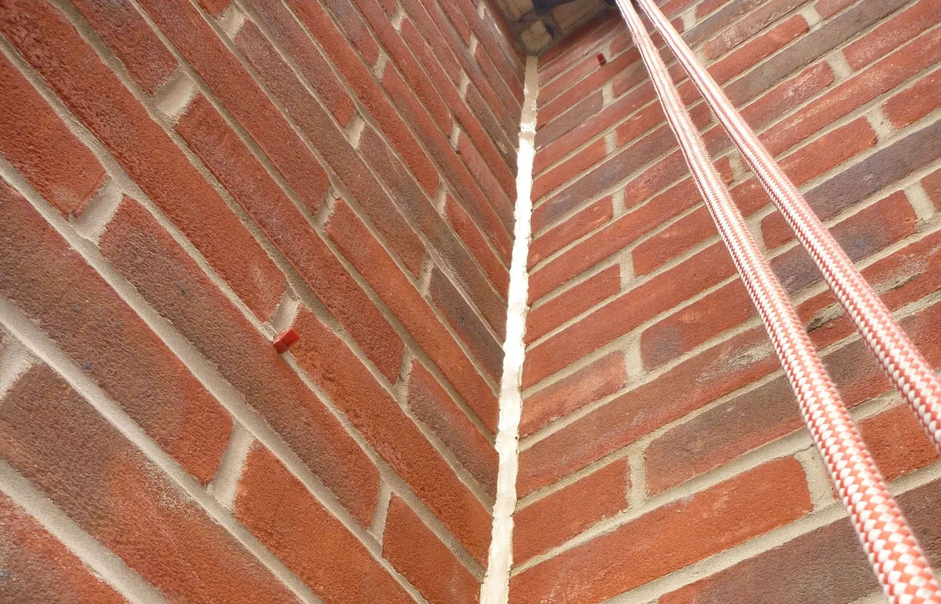 Rope access technicians repairing expansion joints on a high-rise building to prevent water ingress and structural movement in London.