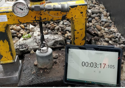 Rope access technician performing an eyebolt destruction test to verify load capacity and compliance with safety standards.